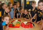 Alex and Zoe Kingsley (seated, centre) were so proud to know that Dad had sent in fruit and veg from Rainbow Fruit to make a delicious platter for their fellow Year 1/2 students