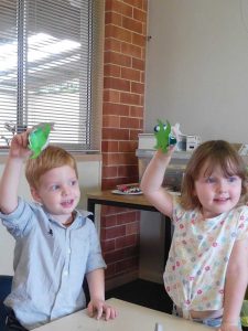 Fletcher and Scarlett hold up their recycled craft at Tin Can Bay Library