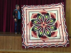 Maree Sayers proudly displays her beautiful Judy Neimeyer Quilt, ‘Vintage Rose’. Judy Niemeyer is an international instructor known for her foundation paper piecing techniques and quilt patterns.