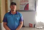 Ben Andrews of Beach to Bay Pest Management proudly standing in front of the workbench his company sponsored