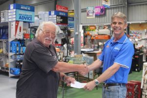 Mark Denham from Mitre 10 presenting Bryan Phillips with a cheque for bench sponsorship