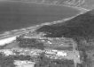 An aerial photo of Rainbow Beach from 1965 showing the Mineral Sands Building, the three mining houses, the Surf Club, Phil Rogers’ shop and a few caravans (supplied Garry Hewitt)