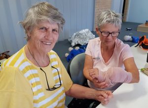 Katrina from QCWA practices bandaging techniques on YAP volunteer Julie