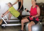 Heather Parker using the Pilates Reformer to release tight areas and strengthen weak places, with Sarah Booth, Pilates and personal trainer, and Lexie Hansen, toning and building strength utilising weights and fitball in the studio