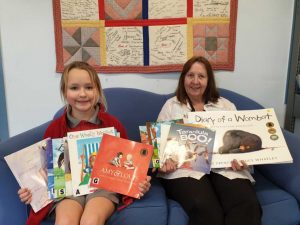 Amanda Geurts and librarian Mrs Sue Dan with some of the books donated by the Geurts family the to Tin Can Bay school library