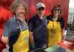 Tin Can Bay Lions Club volunteers Pat Green from Mitre 10, Rob and Ilse Storrie sizzled sausages at the Rainbow Beach Market