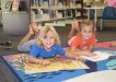 Our libraries have lots on for the school break: Damon and Lelania enjoy a good book at First 5 Forever, Rainbow Beach Library