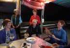 Octogenarian Norma Sanderson celebrating with fellow Dragons and friends at TCB Yacht Club: Andra Casey, Pam Corey, Vic Vella, Elaine Dimmock, and Norma, reading her handmade birthday card