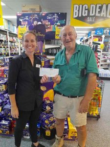 Kristy from Rainbow Beach IGA presenting Tony with a donation cheque