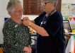 QCWA - Mollie receiving her replacement Gold Service Badge from Wendy