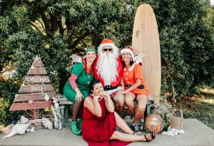 Santa and his elf last year with event organiser Elisa Seul and sleigh co-pilot Di from Rainbow Beach Helicopters. Get yourself on Santa’s nice list this year and visit him on 11 December.