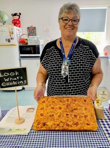  Branch President Wendy with a Trinidadian macaroni pie made by Country Kitchens Facilitator Gabriella